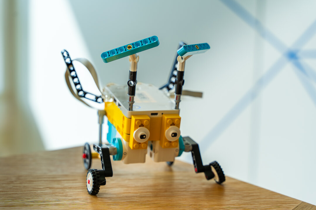 Legoroboter in Form eines Hüpfers Ein Legoroboter mit Fühlern, der an einen Heuhüpfer erinnern soll. Der Programmierblock bildet den Körper, blaue schmale Klemmblausteine die Fühler.